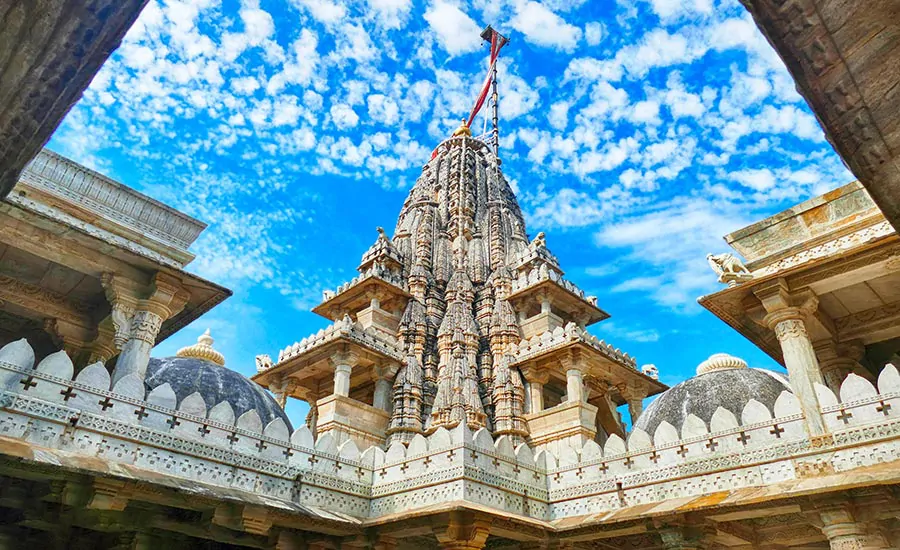 Świątynia dżinijska Ranakpur (Indie), z kopułami i bogatymi zdobieniami z marmutu, na tle błękitnego nieba. Dżinizm w Indiach.