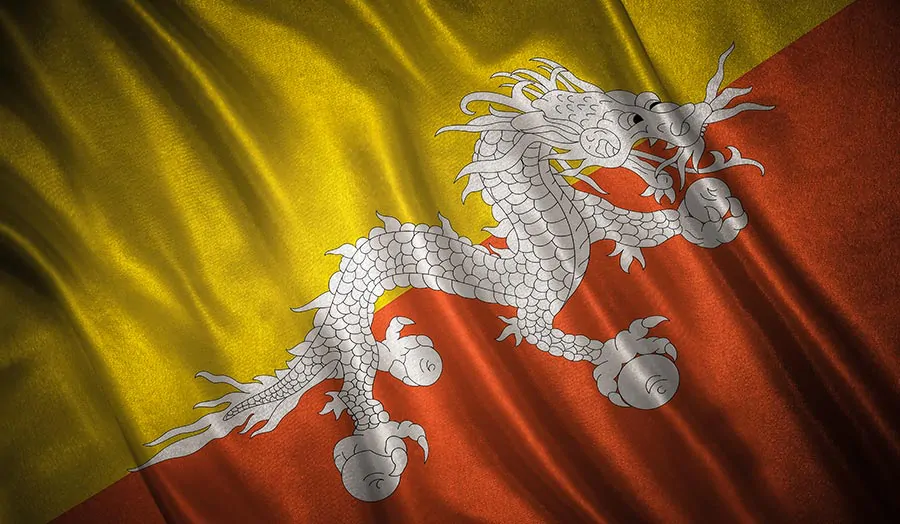 Flaga Bhutanu z wyrazistym wzorem smoka na pofalowanym materiale, tworząca poczucie ruchu i głębi