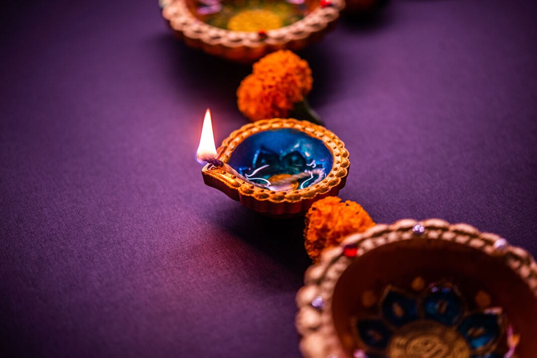 Tradycyjna lampka diya na ciemnofioletowym tle, symbolizująca święto świateł Diwali w Indiach i zwycięstwo dobra nad złem