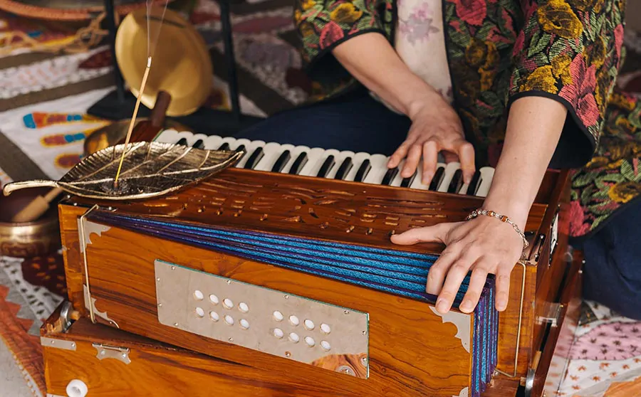 Osoba grająca na harmonium, tradycyjnym indyjskim instrumencie klawiszowym.