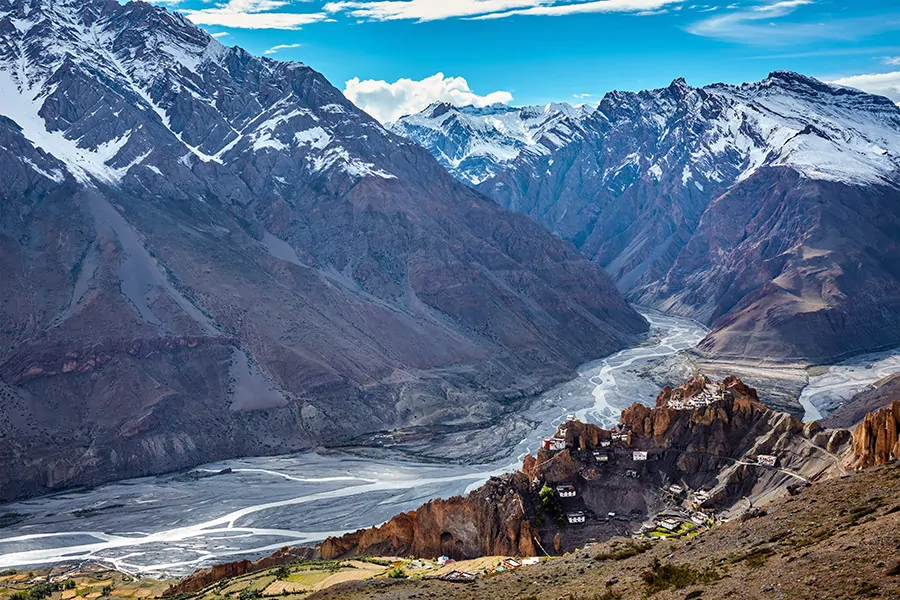 Góry Himalaje i indyjska dolina Spiti. Ośnieżone szczyty górskie z wioską Dhankar na pierwszym planie.